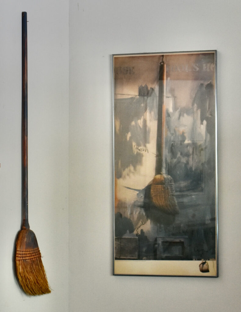 broom hanging next to poster of Jasper Johns painting "Fool's House"