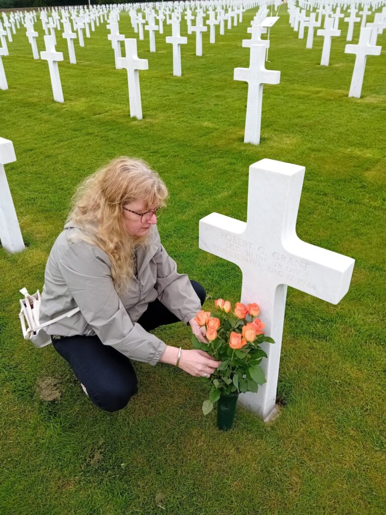 Ms. Blokland who adopted Sgt. Robert Grant's grave placing roses in April