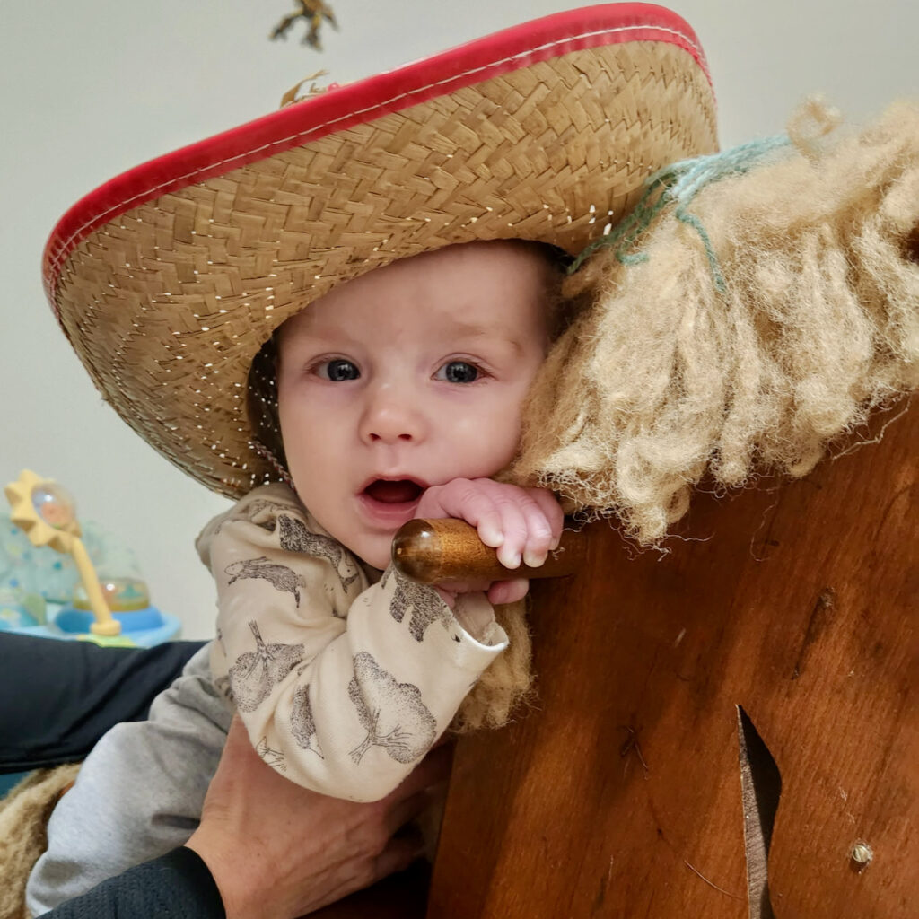David wearing cowboy hat riding rocking horse