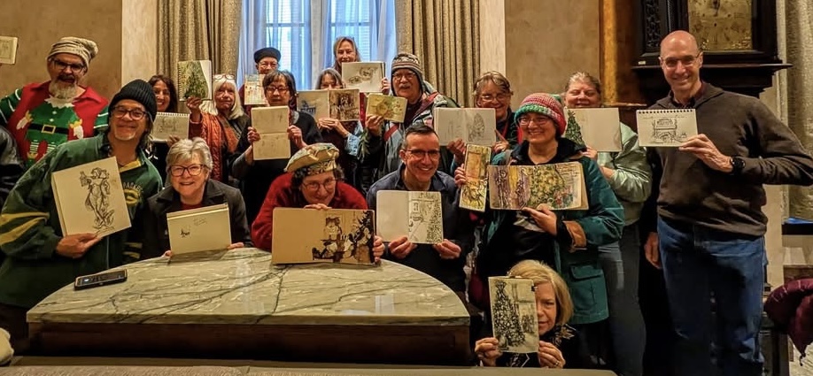 group of artist holding up sketches of Milwaukee's Pfister Hotel